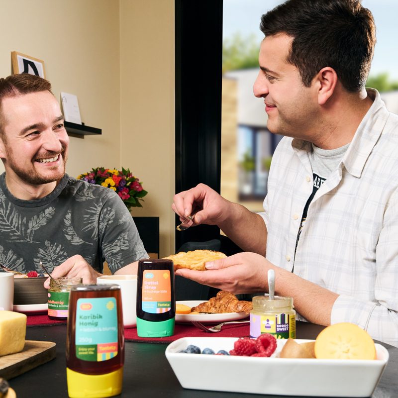 zwei Männer genießen Honig zum Frühstück