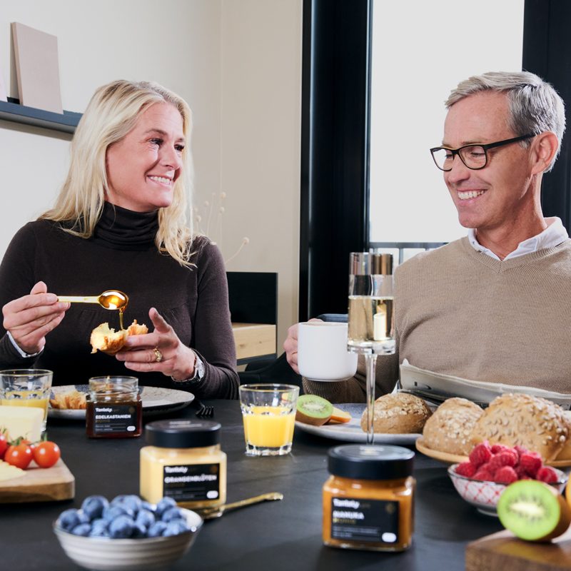 Ein Ehepaar isst Honig beim Frühstück